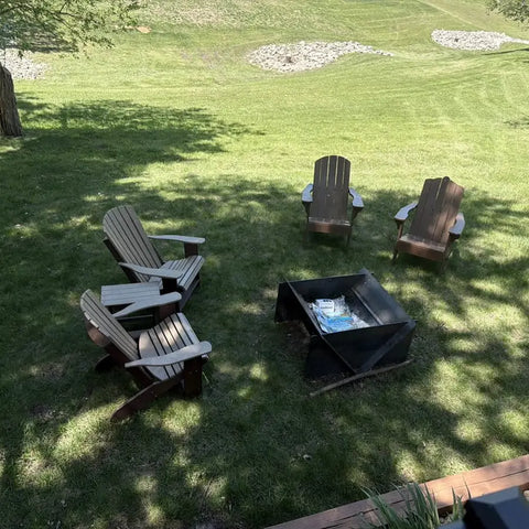 Adirondack chairs around a customer fire pit on a lawn